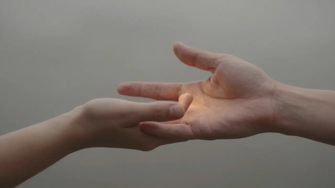 Manos tocándose suavemente en un ambiente neblinoso, simbolizando mindfulness y calma mental